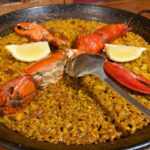 Paella de mariscos con langosta y limón.