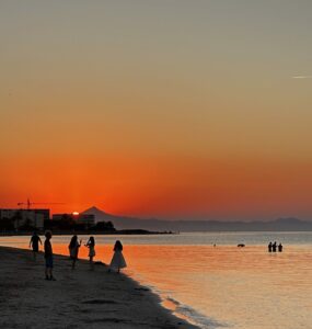 Personas contemplan el atardecer en la playa